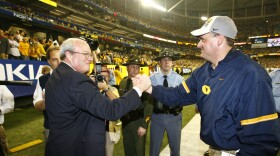 Paul Hoolahan shaking hands with former West Virginia head coach Rich Rodriguez (right) in 2006.