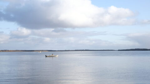A man untangles his net in his boat on the Kuskokwim River in Bethel on Oct. 10, 2023.