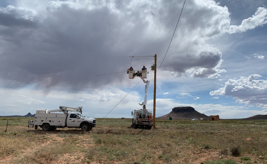 A crew from PNM Electric hooks up a power line to the Billies' home. On the Navajo Nation, the homes are so spread out that it costs $40,000 on average to hook up one home to the electrical grid.