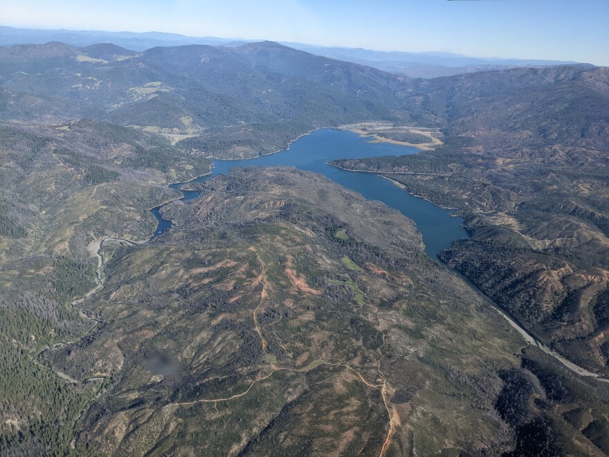 A lake surrounded by mountains and wilderness, seen from above.