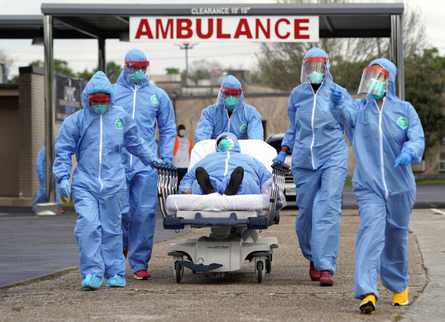 A person is taken on a stretcher into the United Memorial Medical Center after going through testing for COVID-19 Thursday, March 19, 2020, in Houston. On the third anniversary of the COVID-19 pandemic in 2023, the virus is still spreading and the death toll is nearing 7 million worldwide. Yet most people have resumed their normal lives, thanks to a wall of immunity built from infections and vaccines.