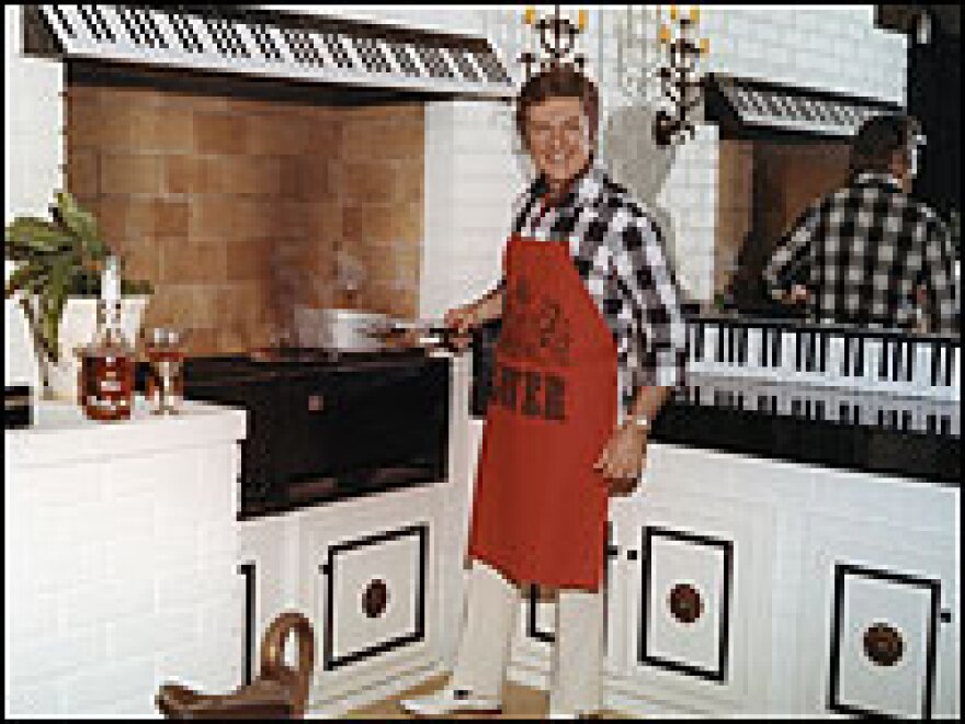 Liberace cooks in his Hollywood Hills home, 1969-70. Twenty years after his death, more than 80 of the pianist's favorite recipes have been gathered into a retro cookbook.