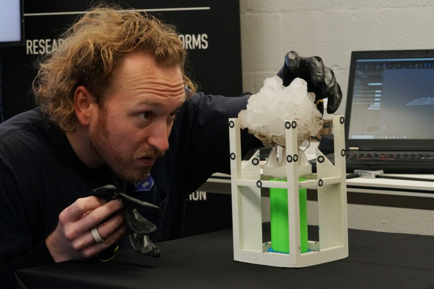 Lucas Faulkner of the Insurance Institute for Business and Home Safety prepares a hailstone for scanning.