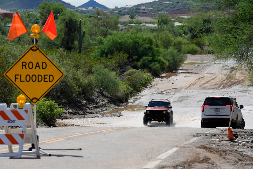 Vehicles navigate on a road after torrential rains moved through the Phoenix metro area, Tuesday, Sept. 29, 2026, in Anthem, Ariz.
