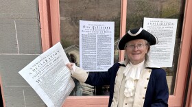 Lake City resident Schuyler Denham, dressed in colonial attire, holds a copy of the the Declaration of Independence in front of the Hinsdale County Museum.