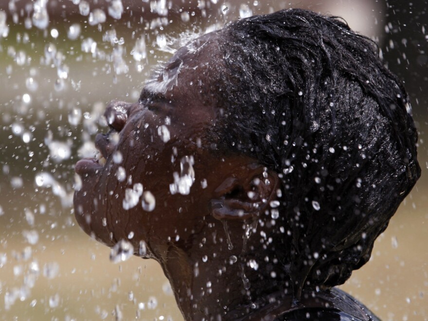 Miniimah Rashid, 13, let the water from one of the fountains at the Windsor Village Spray Park in Indianapolis run over her face as temperatures rose Tuesday (July 19, 2011).