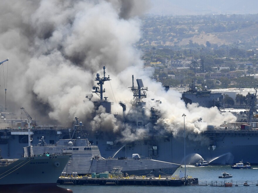 Smoke rises from the USS Bonhomme Richard at Naval Base San Diego in July, after an explosion and fire on board the ship. The Navy announced Monday the ship will be decommissioned.