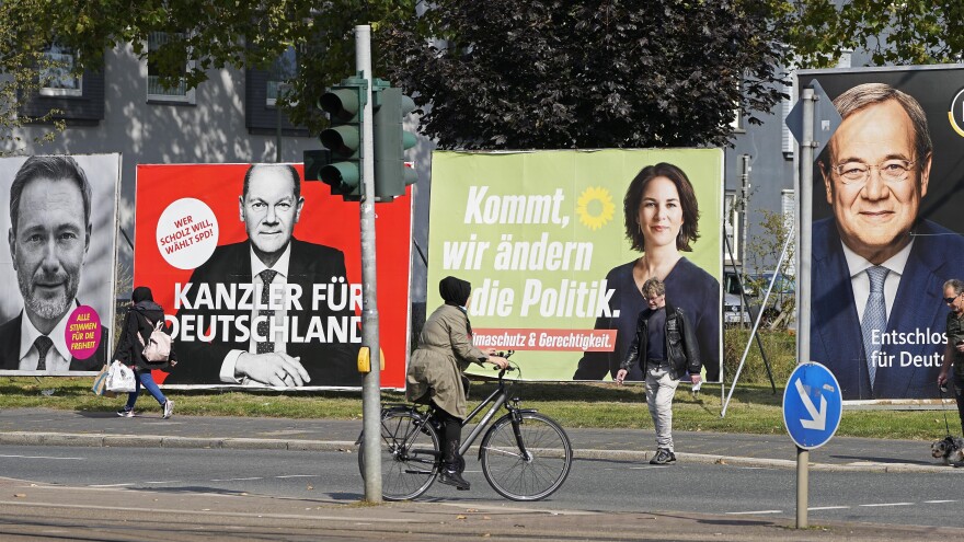 On Thursday, people in Gelsenkirchen, Germany, pass election posters of chancellor candidates Armin Laschet (from right) of the Christian Democratic Union, Annalena Baerbock of the Greens, Olaf Scholz of the Social Democratic Party and Christian Lindner of the Free Democratic Party.