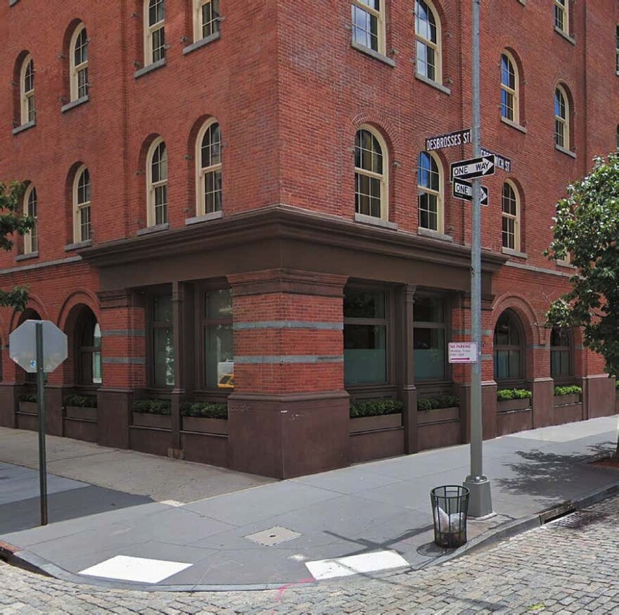 color hoto of brick building with street sign in front reading Desbrosses Street