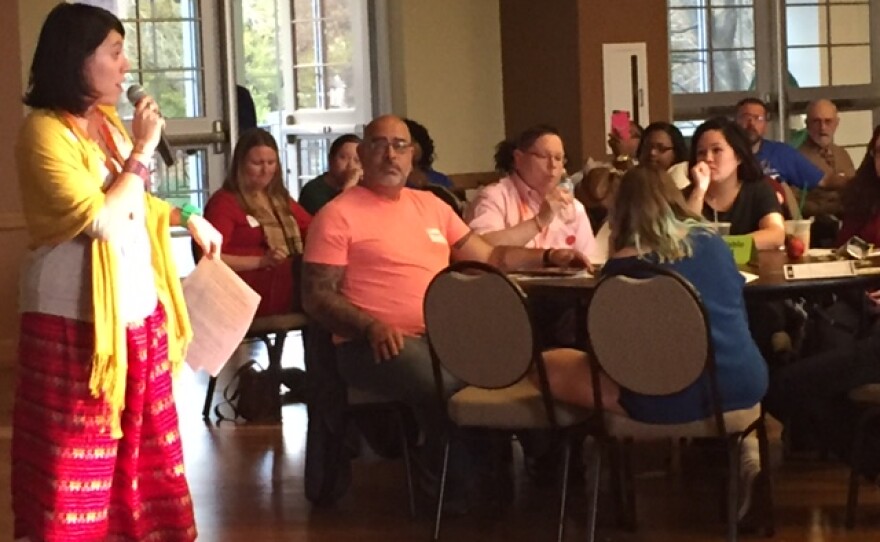Woman talking on a microphone to audience at Humanity Summit