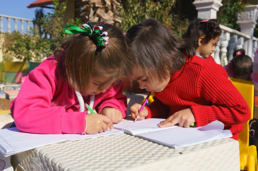 Two Syrian girls color at Bayti orphanage in Reyhanli, Turkey, just across the border from Syria. Many young Syrian refugees have lost one or both parents, but space is limited at orphanages in the city.