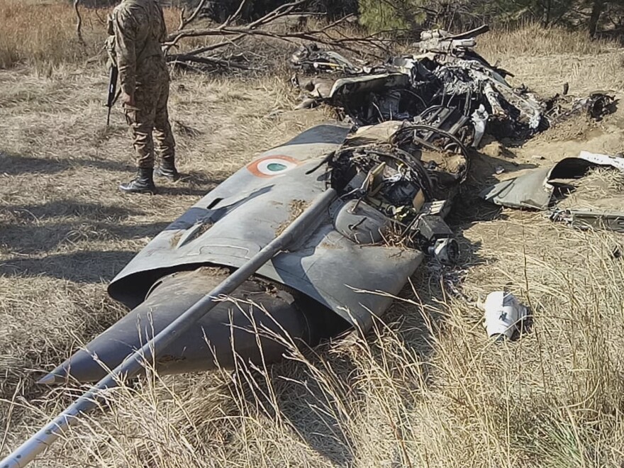A Pakistani soldier stands guard near the wreckage of an Indian plane shot down by the Pakistan military on Wednesday, in Hurran, near the Line of Control in Pakistani Kashmir, on Thursday.