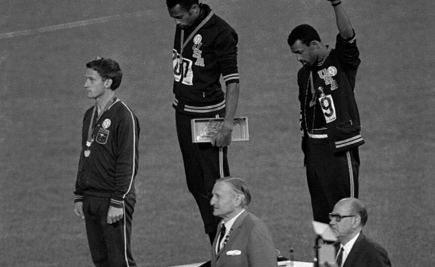Athletes Tommie Smith (top center) and John Carlos (top right) extend their fists during the playing of "The Star-Spangled Banner" after Smith received the gold and Carlos the bronze for the 200-meter run at the 1968 Summer Olympic Games in Mexico City.