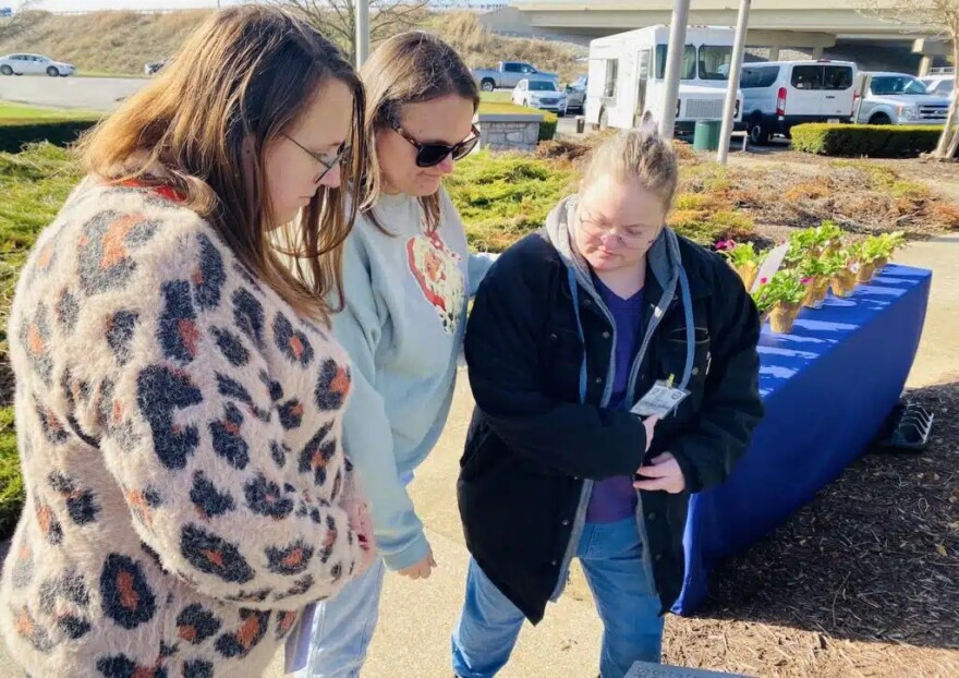 Cousins (from left) Kathleen Mollohan, Melissa Larimore and Jessica Grigsby pause at the stone marker bearing the name of their grandfather, Command Sgt. Maj. Haslund Black in Hopkinsville’s Gander Memorial Park. Black was among the soldiers who died in the Gander, Newfoundland, crash in 1985.