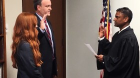 St. Louis County Councilman Sam Page (left), joined by his wife, Dr. Jennifer Page, is sworn in by Administrative Hearing Commissioner Sreenivasa Rao Dandamudi Monday to take over as county executive following Steve Stenger's resignation from the office.