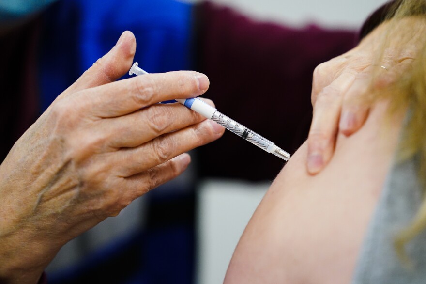 A health worker administers a dose of a COVID-19 vaccine during a vaccination clinic in Chester, Pa., on Dec. 15, 2021.