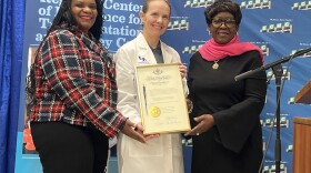 At center, Dr. Liise Kayler, director of ECMC's Kidney Transplant Center, holds a framed pen and certificate marking the signing of the New York HEART Act into law. With her are, left to right, State Senator April Baskin and Assembly Majority Leader Crystal Peoples-Stokes, who worked to get the legislation passed.