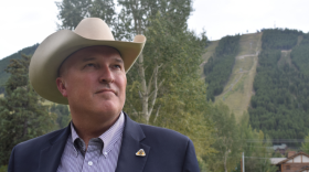 A man in a cowboy hat looks off into the distance.