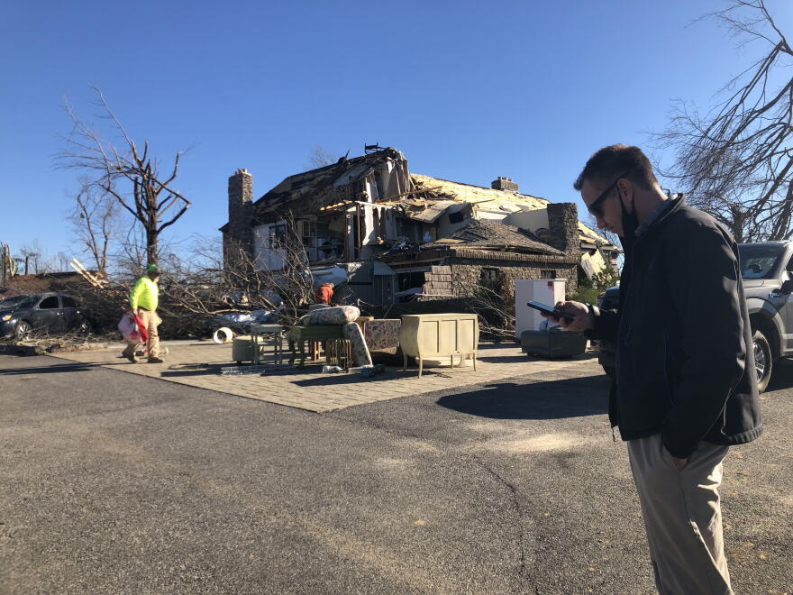 National Weather Service meteorologist Kelsey Angle checks the latitude and longitude of a damage site he's surveying in Mayfield, Kentucky, Monday as he crisscrosses the path of a tornado system that tore across over 200-miles and four states this weekend.