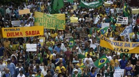 Demonstrators hold banners reading "Institutional crisis in Brazil" and "Dilma knew" as they take part in a protest demanding the impeachment of Brazilian re-elected President Dilma Rousseff in Sao Paulo, Brazil on November 15, 2014. AFP PHOTO / Miguel SCHINCARIOL        (Photo credit should read Miguel Schincariol/AFP via Getty Images)