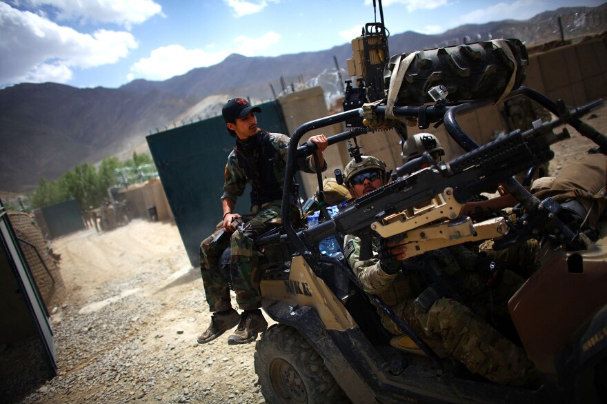 An Afghan soldier rides on the back of a U.S. Green Beret vehicle near the village of Kasan, west of Kabul, in 2013. American combat forces will leave by year's end, but it's not clear how the Afghan forces will handle the Taliban threat.