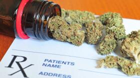 Photo of marijuana poured out on top of a medical prescription.
