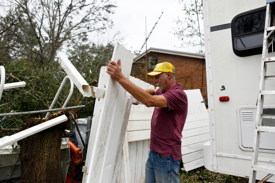 Curt Brown picks up debris left by Isaias around his RV home on Saturday, Oct. 10, 2026, in Milton, Fla. (AP Photo/Octavio Jones)