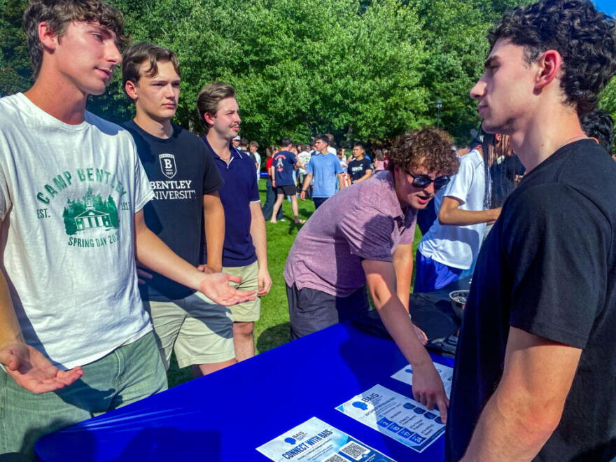 Members of the Bentley University Artificial Intelligence Society recruit members at a Sept. 4, 2026, student activities fair. (Suevon Lee/WBUR)