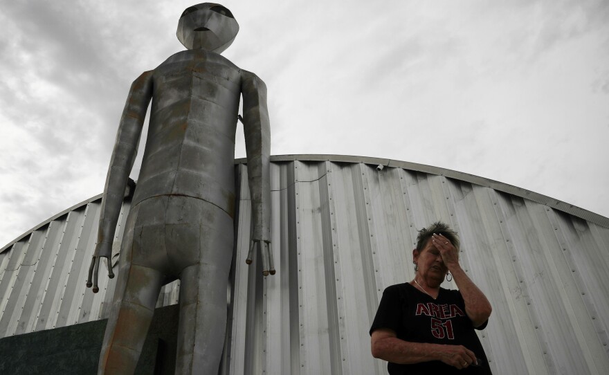Linda Looney wipes her face outside the Alien Research Center, a gift shop on the Extraterrestrial Highway, in Crystal Springs, Nev., in 2019. The tiny desert town is near Area 51, a secret government facility some believe is a research center devoted to studies of space aliens.