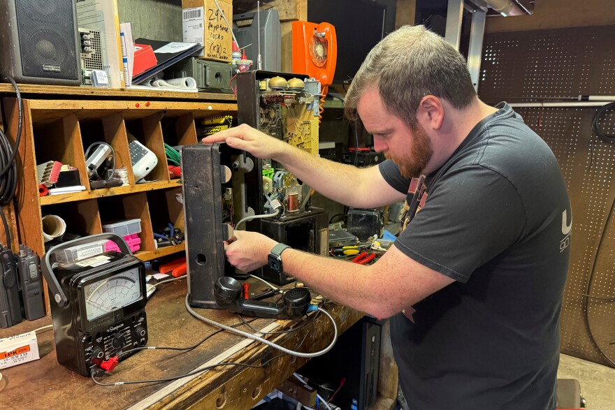 Patrick Schlott repairs an old payphone in his basement workshop on July 16, 2025, in Williamstown, Vt.