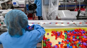 An employee at the Bazooka Brands Ring Pop factory in Moosic helps the pops move along to the next phase of packaging.
