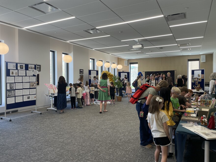 Children and students look at displays on a table.
