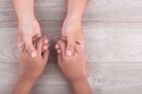 Help and support Concept : Woman holds her young kids hands on brown wooden table background. Free space for text or design