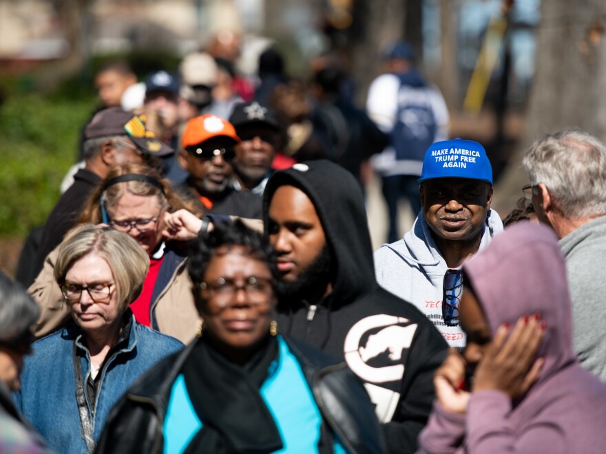 Al Hightower (in blue hat), a Joe Biden supporter, stands in line for early voting for the Democratic presidential primary at the Richland County Election Commission on Thursday in Columbia, S.C.