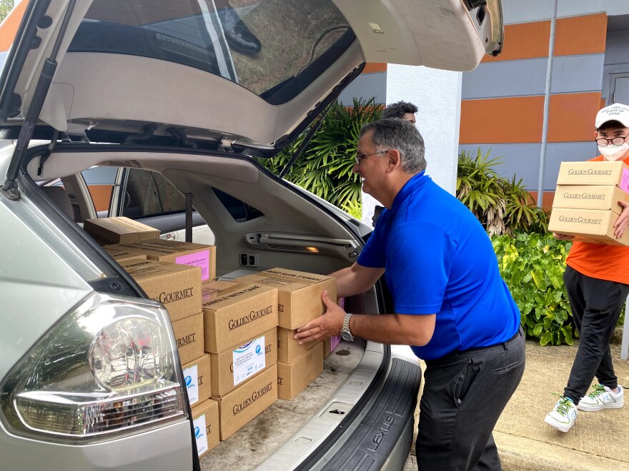  United Homecare President Carlos Martinez loads meal kits into a car. 