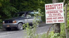 A guard sits in his truck at the entrance to the Darby Coal Mine in Holmes Mill, Kentucky, on May 20, 2006 - the day an explosion in the mine killed five miners. The owners of the mine later failed to pay nearly $3 million in penalties for mine safety violations at Darby and other mines.