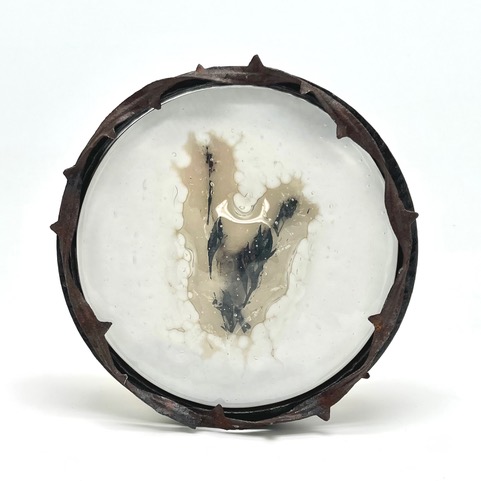 Incineration wildfire encased in a round foggy cameo framed in barbed wire. 